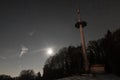 Radio mast in Liebersberg near Grafenau in a full moon winter night, Bavarian forest, Germany