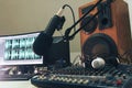 Radio microphone, mixing console and headphones on the background of the monitor