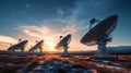 Radio telescopes aligned in the sky at sunset