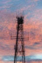 Radio and television broadcasting communications tower in Lightning Ridge back lit by a pink sunset