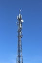 Radio tower with antennas on a blue sky background. Metal construction. Wireless tezhnologii. Transmission of a tele-radio signal. Royalty Free Stock Photo