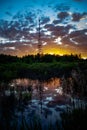 Radio tower and its reflection in the lake in the forest at sunset Royalty Free Stock Photo