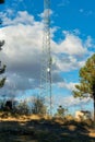 Radio tower with metal legs for cell phone and internet connection in a rural area in afternoon shade with clouds Royalty Free Stock Photo