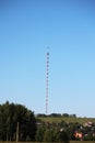 Radio tv tower with guy wires against clear deep blue sky, close up. Red and white lattice design steel structure Royalty Free Stock Photo