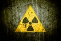 Radioactive atomic nuclear ionizing radiation danger warning symbol in triangular shape painted massive cracked concrete wall Royalty Free Stock Photo