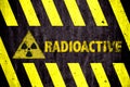 Radioactive ionizing radiation danger symbol and word with yellow and black stripes painted on a massive concrete wall Royalty Free Stock Photo