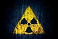 Radioactive ionizing radiation nuclear danger yellow symbol on massive cracked concrete wall dark rustic grunge background