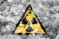 Radioactive substances or ionising radiation hazard warning smoke sign. Triangular warning hazard sign, smoke background. Royalty Free Stock Photo