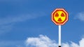 The radioactive symbol on red warning sign with blue sky background