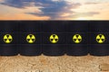 Radioactive waste against dry earth and sky clouds. Environment protection and toxic nuclear pollution concept