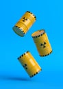 Radioactive waste yellow barrels with radioactive symbol fall on a blue background