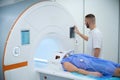 Technologist positioning outpatient for magnetic resonance imaging of brain