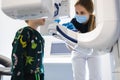 Radiographer taking panoramic teeth radiography to a little boy using modern x-ray machine.