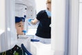 Radiographer taking panoramic teeth radiography to a little boy using modern x-ray machine.