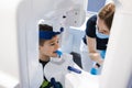 Radiographer taking panoramic teeth radiography to a little boy using modern x-ray machine.