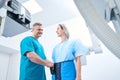 Radiologist at medical center putting lead shield on female patient