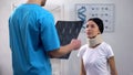 Radiologist with x-ray informing patient about results, lady listening with hope