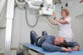 Radiologists Performing X-ray On Patient. Technician Setting Up Machine To X-ray Patient.