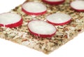 Radish on crispy bread. Stack of wholegrain crispy bread with sunflower, chia and sesames seeds on white background. Royalty Free Stock Photo