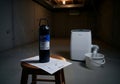 A radon test kit sits on a stool in a basement, a dehumidifier and cobwebs are also visible, suggesting a potential need for home Royalty Free Stock Photo