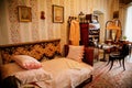 Radun castle interior, Neo-Classical chateau, bedroom, single bed, desk with papers and photos, mirror, chair, clothes hanger,