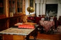 Radun castle interior, Neo-Classical chateau, library and bookshelves, table with tablecloth, glasses and bottles, large stone