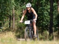 Female biker hold possition through long gravel descent in forest