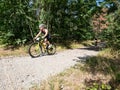 Old man on yellow mtb rides through forest. Sportsman in black