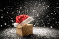 A raffia hat inside a box with snowflakes falling softly against a blurred winter background. Royalty Free Stock Photo