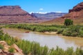 Raft going down Colorado river in Utah desert canyon. La Sal Peak, Mount Waas, Castle Mountain covered in snow on Royalty Free Stock Photo