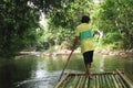Rafting on bamboo rafts on a mountain river in Khao Lak Park, Thailand. Man controls the raft with a long pole, rear view Royalty Free Stock Photo