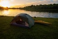 Rafting on kayaks. A tent camp stands on the river bank.