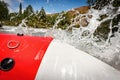 Rafting on a mountain river. Close-up of raft boat side with spray and foam Royalty Free Stock Photo
