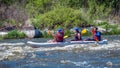 Rafting. Three sportsmen are sailing on a rubber inflatable boat. Teamwork. Water splashes close-up. Ecological tourism Royalty Free Stock Photo