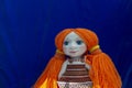 Rag doll with orange hair on blue background