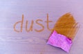 Rag swiping word `Dust`written on dusty wooden surface