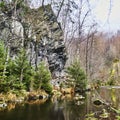 Ragged rock for climbers on the bank of the Oker River in the Oker Valley, surrounded by forest with fir trees Royalty Free Stock Photo