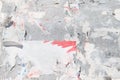 Ragged white and red posters on gray board background. Old bilboard with peeled placard. Crumpled paper texture background. Royalty Free Stock Photo