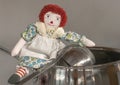 Raggedy Ann sits with pots and pans cooking. Text space available. Size comparison. Royalty Free Stock Photo