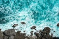 Raging blue ocean waves break on rocks