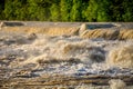 Raging flooded river flowing over man made cascades Royalty Free Stock Photo