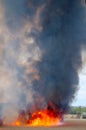 Raging forest spring fires. Burning dry grass, reed along lake. Grass is burning in meadow. Ecological catastrophy. Fire and smoke Royalty Free Stock Photo