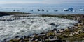 Raging meltwater river running into the sea at Camp Frieda on the Disko Bay coast, Greenland