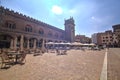 Ragione palace and square in front of it with tables of restaurant full of people