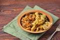 Ragout, stewed beef with cabbage and dough dumplings in a ceramic plate on brown wooden background. Cabbage recipes