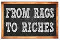 FROM RAGS TO RICHES words on black wooden frame school blackboard Royalty Free Stock Photo
