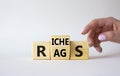 Rags vs Riches symbol. Businessman hand points at wooden cubes with words Rags and Riches. Beautiful white background. Rags vs Royalty Free Stock Photo