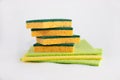 Rags and yellow-green sponges for washing dishes and kitchens are in a pile on a white background. Cool plan. The concept of