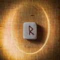 Raidho. Handmade scandinavian wooden runes on a wooden vintage background in a circle of light. Concept of fortune