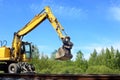Rail excavator working with rubble. Royalty Free Stock Photo